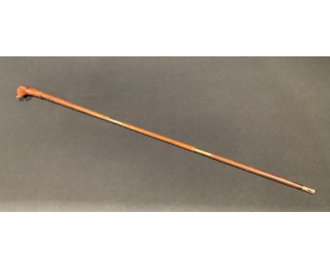 A folk art novelty walking stick, the handle carved as the head of a dog, associated shaft, 88cm long 