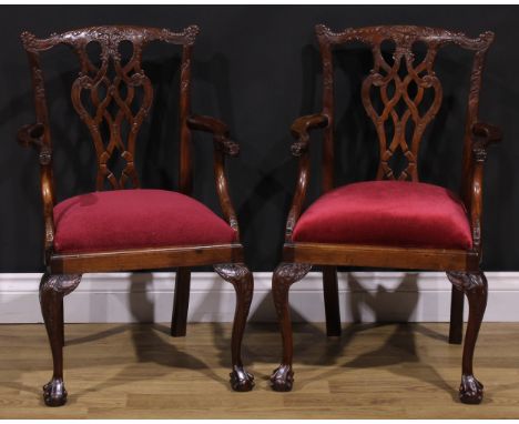 A pair of Chippendale Revival mahogany child’s elbow chairs, each shaped back carved with acanthus, flower heads and bell hus