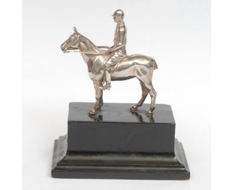 A George V silver equestrian model, cast as a polo player on horseback, ebonised base, 14cm high overall, retailed by Mappin 