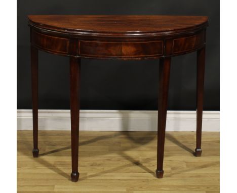 A George III mahogany demilune card table, hinged top with moulded edge enclosing a baize lined playing surface, tapered squa