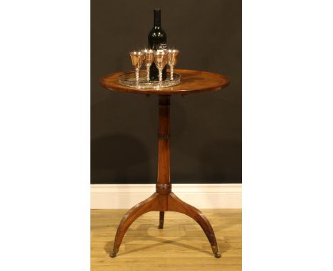 A Regency mahogany tripod occasional table, dished circular tilting top, ring-turned column, reeded downswept legs, brass cas