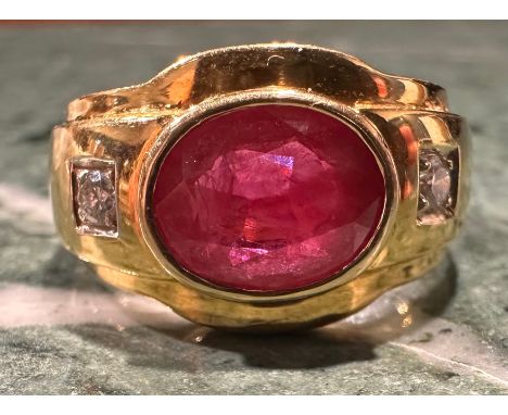 A ruby and diamond ring, central oval rub over set ruby approx 2.80ct, between round brilliant cut diamond accented shoulders
