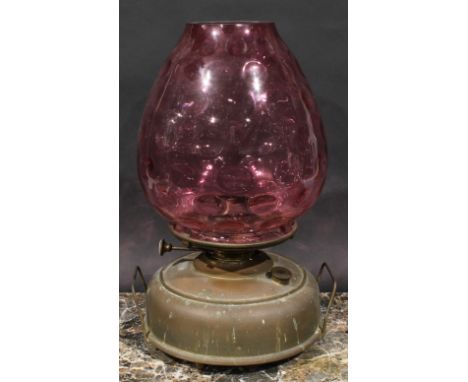 A late 19th century brass heater lamp, coin dot cranberry glass shade, 41cm high 