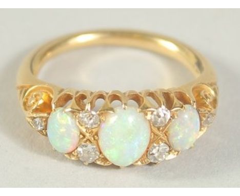 A THREE STONE OPAL AND SIX STONE DIAMOND RING. Size H.