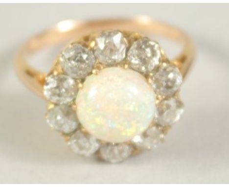 A GOOD OPAL AND DIAMOND CLUSTER RING with central opal and ten diamonds. Size M.