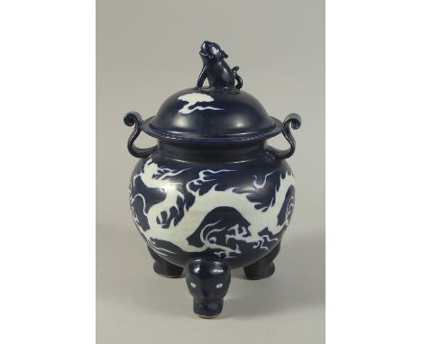 A CHINESE SACRIFICIAL BLUE TRIPOD CENSER AND COVER, the body with incised white dragons. 29cms high.