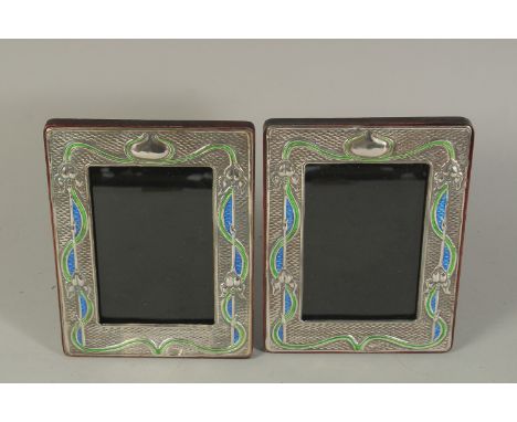 A PAIR OF ART DECO DESIGN SILVER AND BLUE ENAMEL PHOTOGRAPH FRAMES. 7.5 x 6ins.