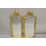 A SMALL PAIR OF GILTWOOD NARROW MIRRORS with scroll tops. 3ft 9ins high x 1ft 2ins wide.