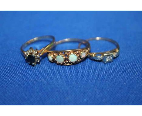 THREE GOLD RINGS
including a diamond solitaire, a four stone opal ring and a sapphire and diamond cluster