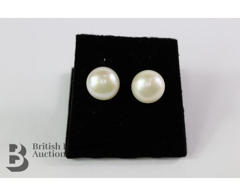 A pair of button pearl earrings on silver posts, the pearls measure 10 mm in diameter.&nbsp;