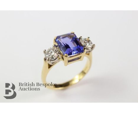 Vivid 18ct Yellow Gold 3ct Tanzanite and diamond ring. The violet emerald-cut stone approx 10 x 8mm surrounded by approx 1ct 