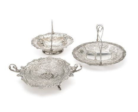 THREE SILVER SWEETMEAT BASKETS one a George III shaped oval example, pierced and chased with beading and scroll foliage, swin