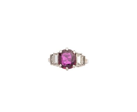 RUBY AND DIAMOND RING, 1950s claw set with an oval mixed-cut ruby set between graduated baguette diamond shoulders, ring size