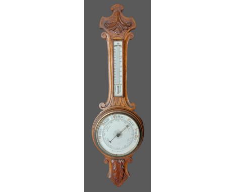 An Edwardian carved oak Aneroid barometer thermometer 