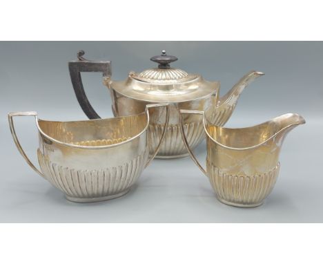 A George V silver three piece tea service comprising teapot, two handled sucrier and cream jug, all of half lobed form, Birmi