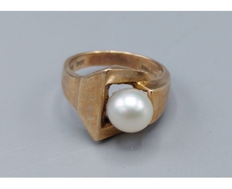 A 9ct gold and pearl ring set with single pearl within an abstract setting, ring size K, 4.2gms 