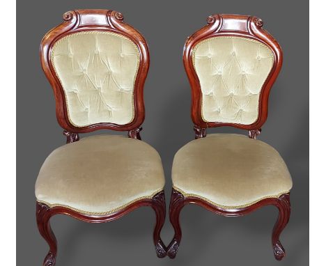 A pair of 19th Century French mahogany side chairs, each with a partly button upholstered back above an overstuff seat raised