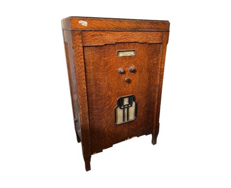 Oak Cased Art Deco Style Radiogram. Record player at the top under lid, radio tuner to the front. Has peripheral accessories 