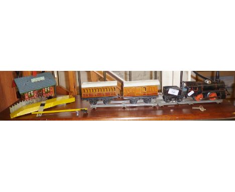 A pre-war model train by Karl Bub (KBN) "O" gauge clockwork engine and tender with two carriages, a station and partial platf