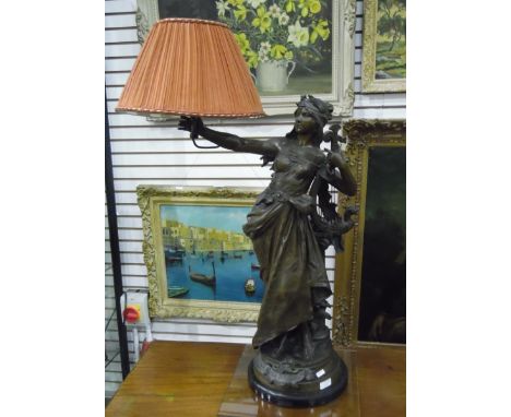 Victorian spelter table lamp in the form of a maiden clutching a harp-type instrument, holding the lamp in an outstretched ri