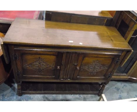 Jacobean-style drop-flap oak cupboard, the pair of lozenge carved panel doors enclosing shelf, on baluster turned legs with p