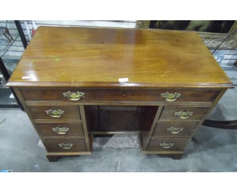 Reproduction mahogany kneehole desk having one frieze drawer over three short drawers and cupboard to kneehole, on bracket fe