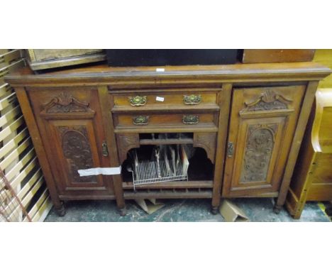 Edwardian walnut sideboard, the central two drawers and dog kennel flanked by two cupboards enclosed with carved panel doors,