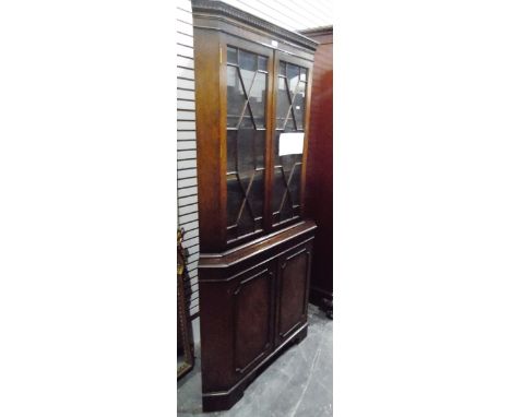 Georgian-style mahogany corner cupboard with dentil cornice, the pair of astragal-glazed doors enclosing shelves, with pair o