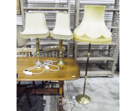 Brass reeded lamp standard on circular platform base and a pair of brass table lamps 