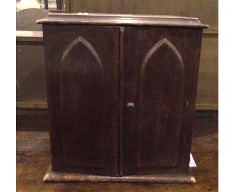 Late Victorian oak small cabinet with moulded edge top, the pair of lancet panel doors enclosing six small drawers, originall