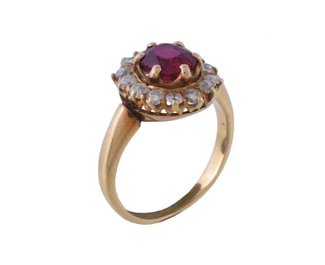  A ruby and diamond cluster ring,   the central oval cut ruby  claw set within a surround of old brilliant cut diamonds, appr