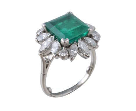  A 1980s emerald and diamond cluster ring,   the square shaped step cut emerald within a surround of brilliant and marquise c