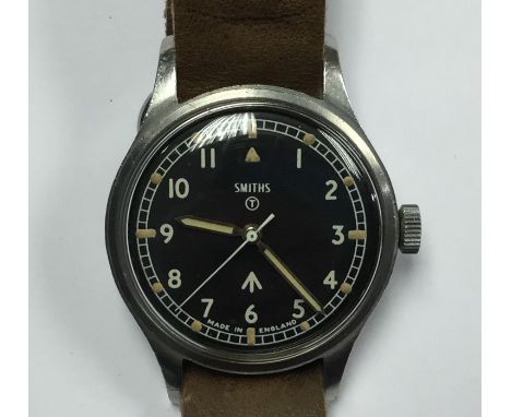 British Army Issue W10 Wristwatch by Smiths. Black dial with Arabic numerals. WD Broad Arrow to dial. Also marked with T in c