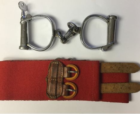 Pair of Hiatt's steel turn key handcuffs with WD Broad Arrow markings along with a Red Military Police Stable Belt. No markin