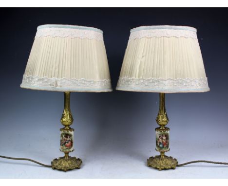 A set of six French gilt metal table lamps, each with a cylindrical ceramic column printed with figures in a garden, 27cm hig