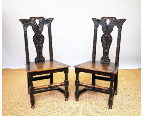 A pair of 18th century style carved oak side chairs, late 19th century, with vase shaped splats decorated with acorns and sol
