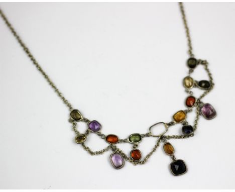 A multi gem set fringe necklace, the native cut stones, collet set within white metal setting and attached fine chain (at fau