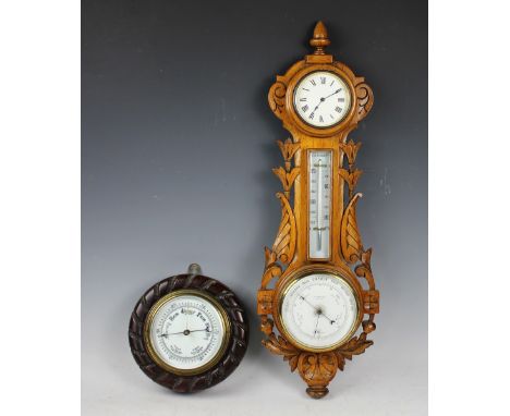 A late Victorian carved golden oak combination barometer time piece, retailed by Lashmore of Oswestry, 64cm, with a smaller o