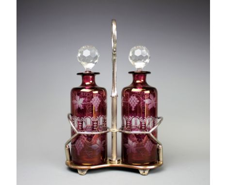 A late 19th century silver plate twin decanter stand, with Bohemian style ruby stained glass decanters and stoppers with frui