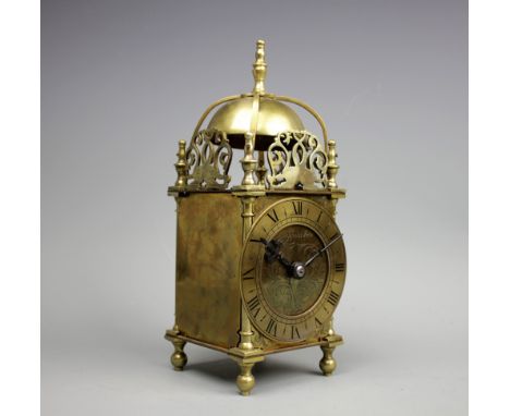 A Mappin & Webb brass lantern clock, with pierced fret dolphin surmounts enclosing a bell top, the dial with Roman numerals t