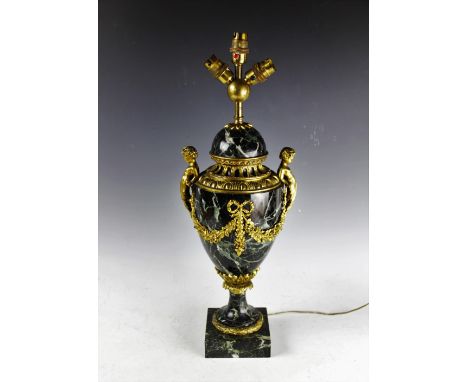 A French gilt brass and veined green marble table lamp, with domed top on a vase shaped body and decorated with cupid handles