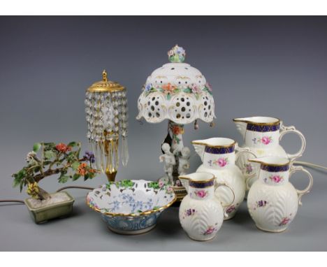 A graduated set of four Coalport Caughley mask head jugs, a Carpie Capodimonte florally encrusted bisque lamp base and shade,