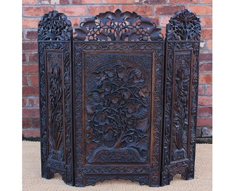 An Anglo-Indian carved fire screen, carved in high relief decorated with scrolling foliage, of triptych form, 102cm high