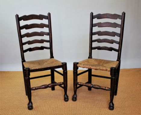 A part set of five oak ladder back dining chairs, with rush seats, on turned legs
