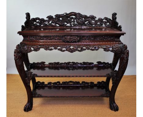 A Chinese carved softwood buffet, with raised three quarter back and frieze drawer, above an under tier, on dragon carved leg