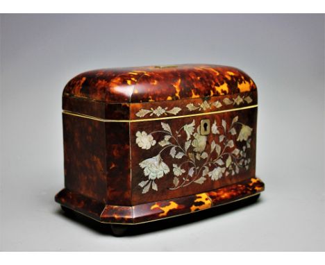 An early 19th century blond tortoiseshell two division tea caddy, the front inlaid with mother of pearl flowers, on copper bu