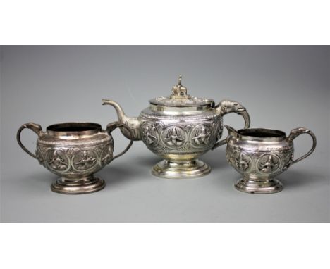 A Burmese silver three piece tea service comprising; a teapot, 14cm high,a twin handled sugar bowl, 8.5cm high and a milk jug