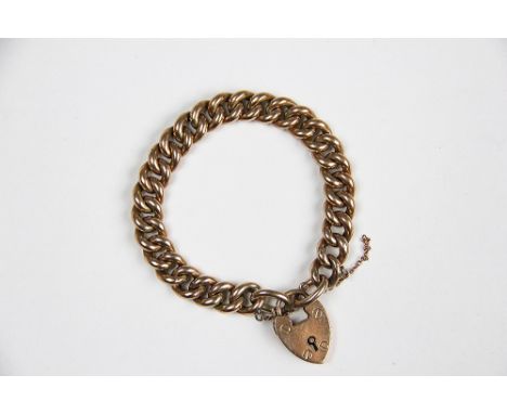 A 9ct yellow gold curb link bracelet with attached padlock clasp and safety chain, stamped '9ct', weight 20.4gms 