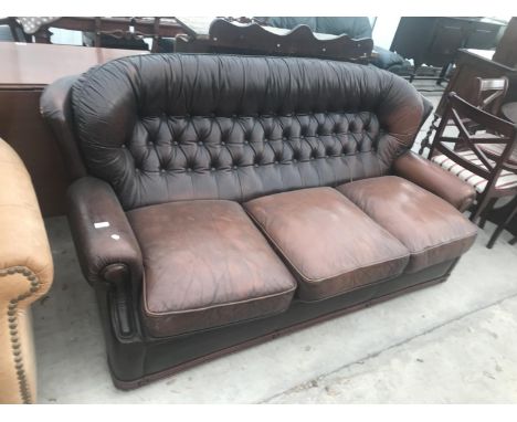 A BROWN LEATHER BUTTON BACK THREE SEATER SOFA 