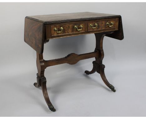 An Edwardian Drop Leaf Two Drawer Sofa Table, the Scrolled Supports Culminating in Claw Feet with Casters, 74cm wide 